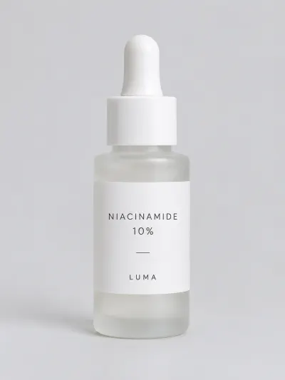 Исходное фото: флакон сыворотки LUMA Niacinamide 10% на сером фоне